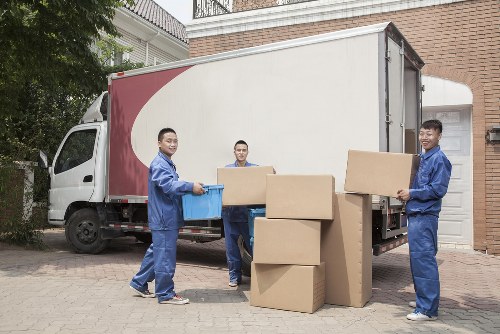 Movers carrying furniture down a stairwell in a terraced Poplar home